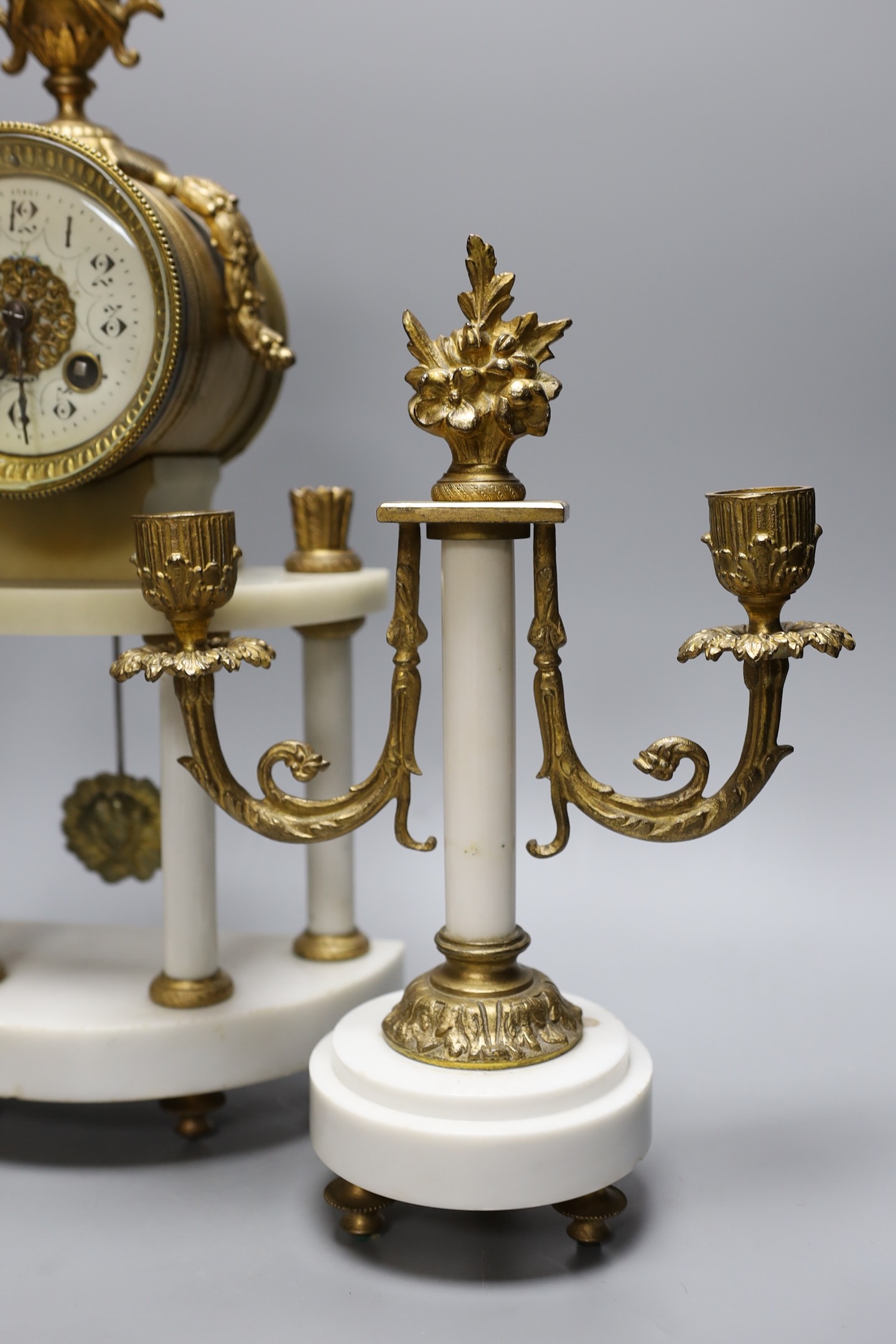 A French white marble and gilt metal clock garniture, 43 cms high